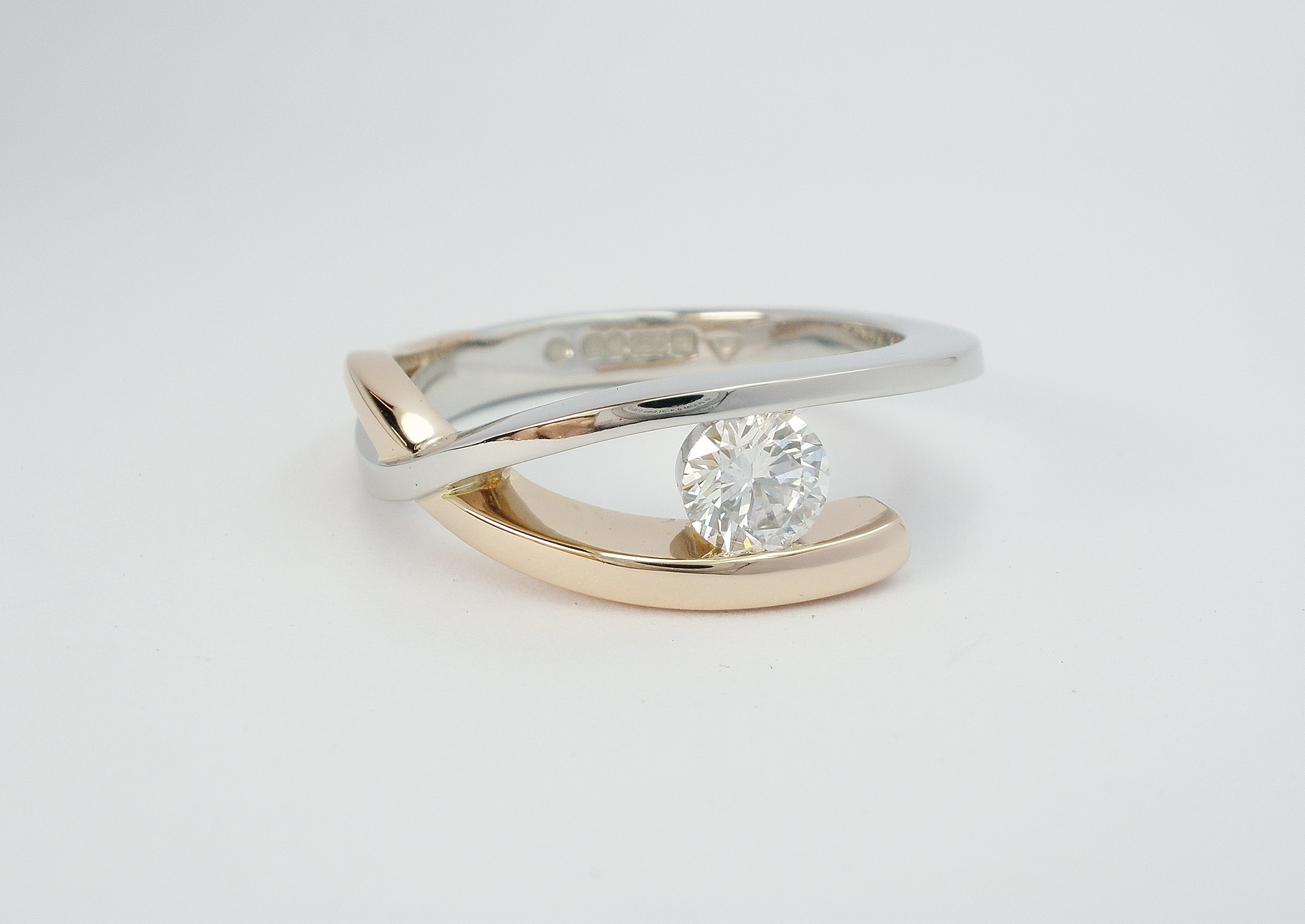 Platinum and 18ct. red gold ( rose gold, pink gold ) open cross-over single stone 0.37ct. round brilliant cut diamond ring. Ideal diamond sizes from 0.35cts. to 0.60cts.