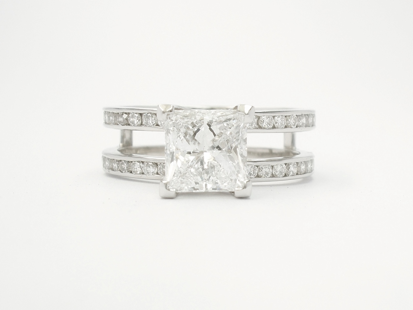 Single stone 1.19ct.'D' colour princess cut diamond 'Embrace' ring set in platinum with round brilliant cut diamonds set in twin shanks. View with wedding ring in shaped wedding ring