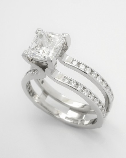 Single stone 1.19ct.'D' colour princess cut diamond 'Embrace' ring set in platinum with round brilliant cut diamonds set in twin shanks. View with wedding ring in shaped wedding ring