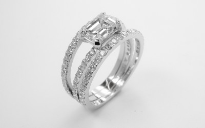 An Emerald cut 1.03ct. diamond of 'E' colour, platinum set on a triple banded ring with cut down brilliant cut diamonds. Ideal diamond sizes 0.75ct. to 1.50ct.