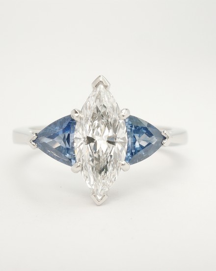 A 3 stone Marquise diamond and trilliant shaped sapphire ring mounted in platinum.