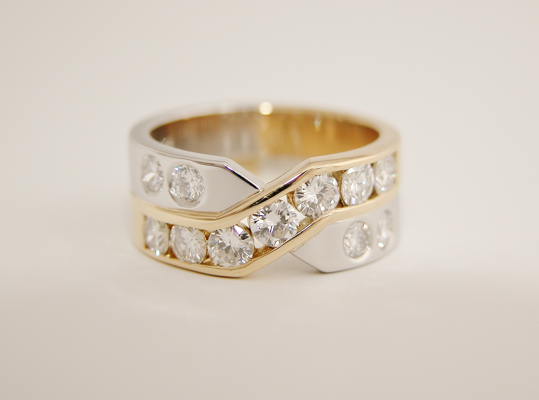 Platinum & 18ct. yellow gold 'X' style ring with 7 round brilliant cut diamonds channel set in the 18ct. yellow gold cross-over panel & 4 flush set diamonds in the platinum.