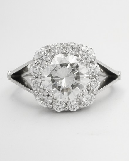 Cushion shaped diamond cluster platinum ring with split shoulder created from 13 round brilliant cut diamonds & diamond set scroll effect round the setting sides. Centre stone 1.90ct 'G' colour.
