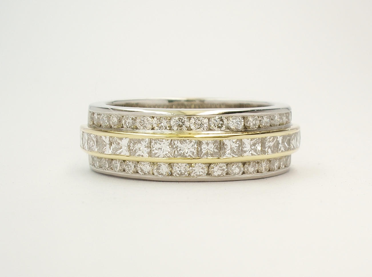 Princess cut diamond and round brilliant cut diamond triple palladium & 18ct. yellow gold eternity ring set to 55% cover.