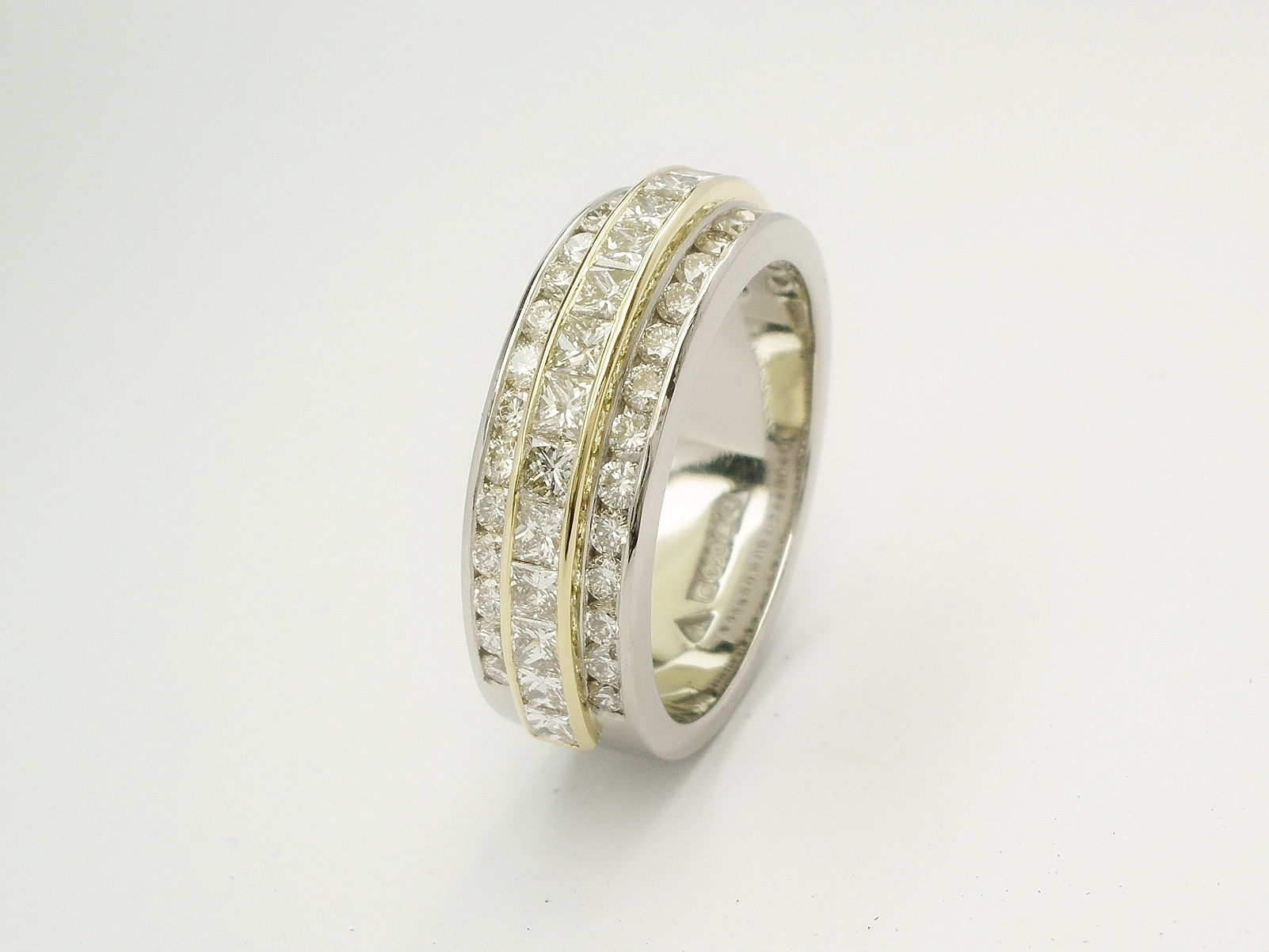 Princess cut diamond and round brilliant cut diamond triple palladium & 18ct. yellow gold eternity ring set to 55% cover.