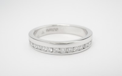 Platinum offset round brilliant cut diamond wedding ring.
