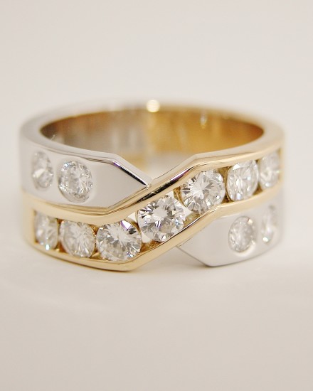 Platinum & 18ct. yellow gold 11 stone channel and flush set diamond cross over style ring.