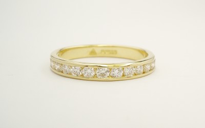 Platinum & channel set round brilliant cut diamond wedding ring set to 55% cover.
