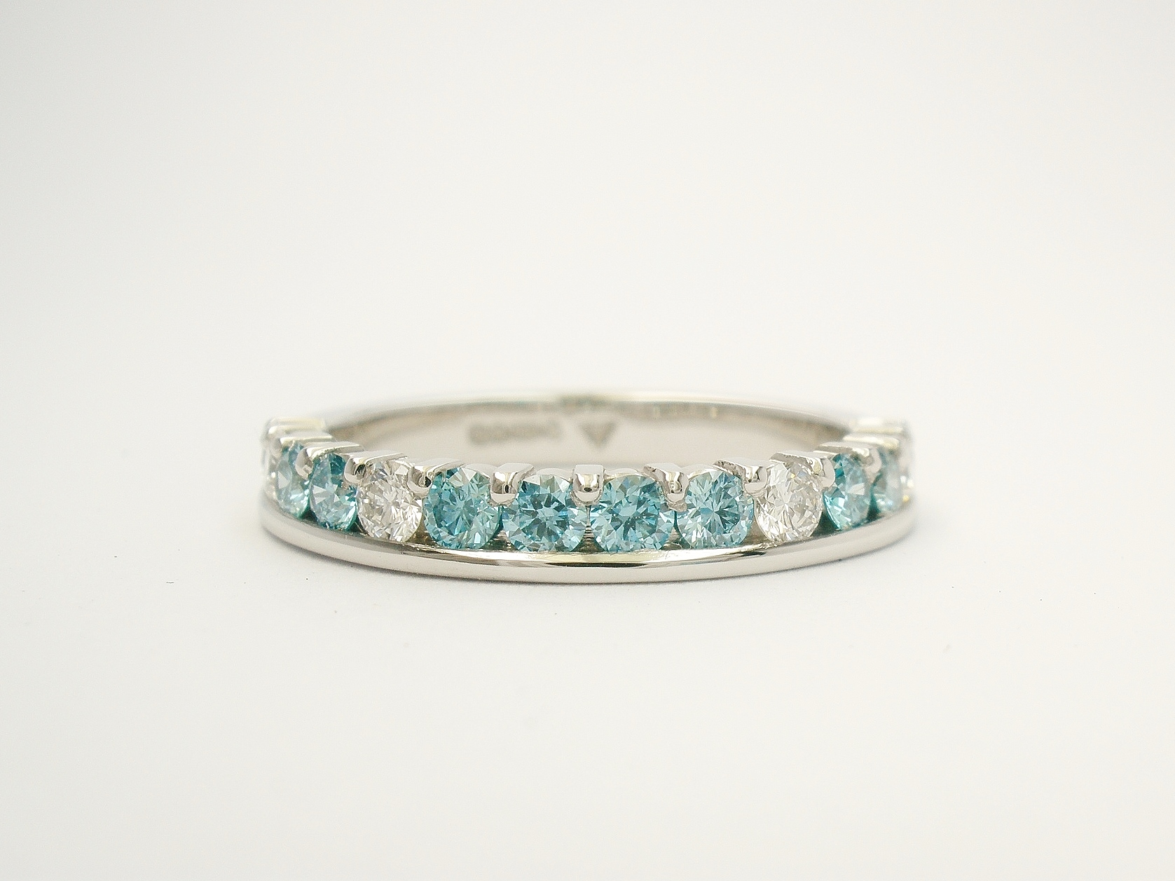 Platinum part channel set round brilliant cut sky blue diamond & white diamond wedding ring set to 55% cover.