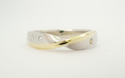 Platinum twist wedding ring edged with an 18ct. yellow gold wire & flush set with round diamonds.