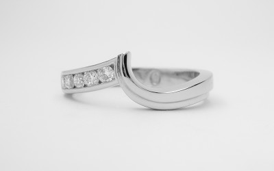 Palladium shaped wedding ring with channel set diamonds on one side & shaped to fit with a single stone diamond open shouldered wishbone cross-over ring.