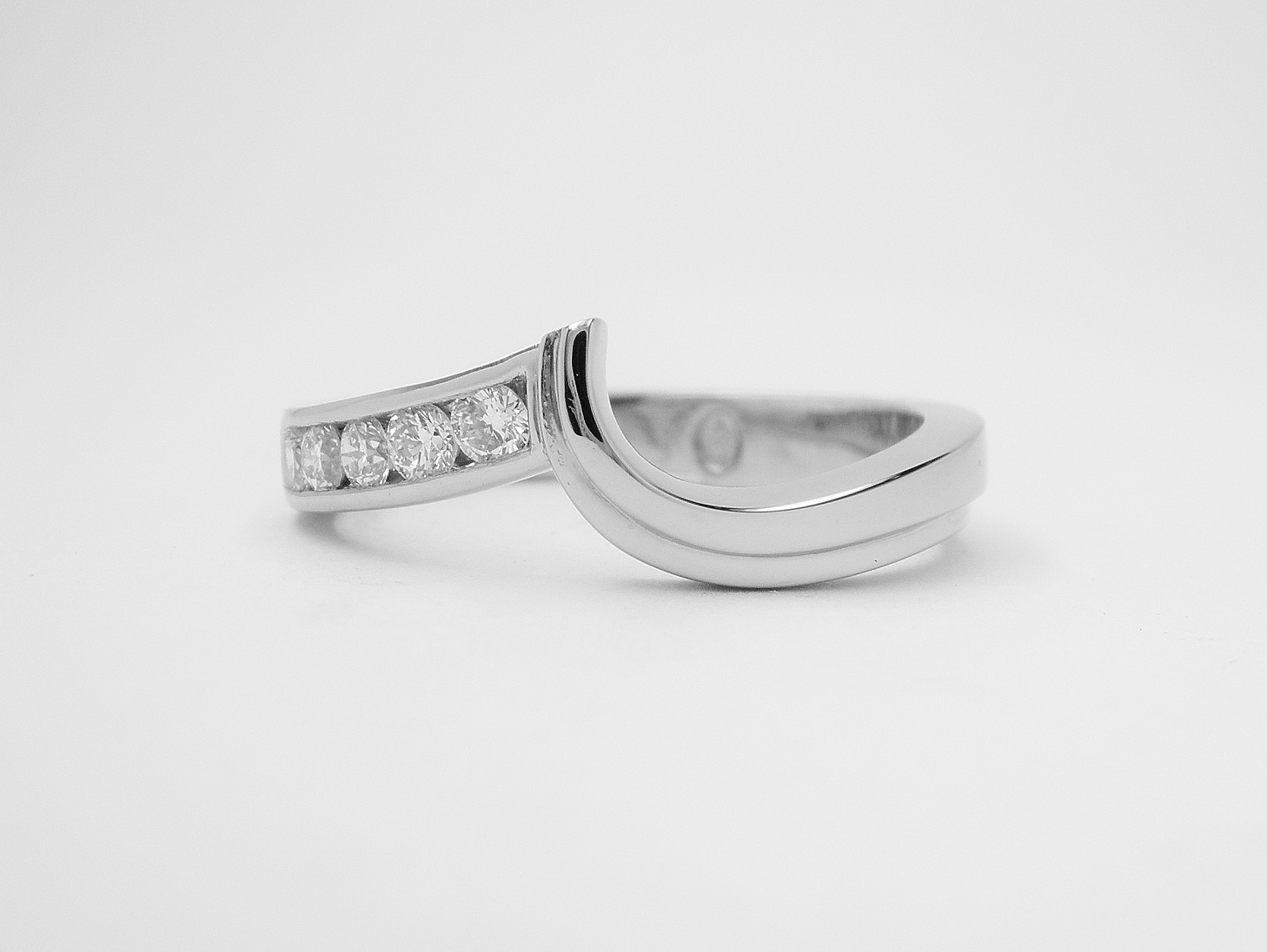 Palladium shaped wedding ring with channel set diamonds on one side & shaped to fit with a single stone diamond open shouldered wishbone cross-over ring.