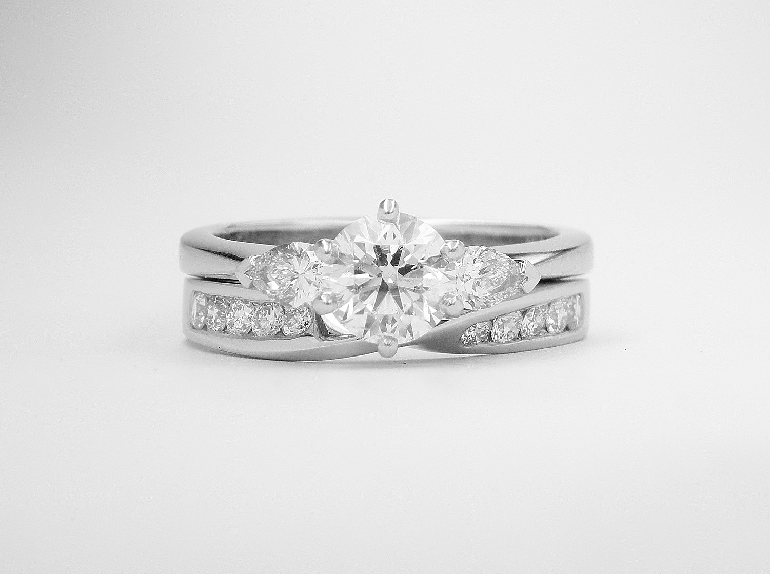 Diamond set 'twist' palladium wedding ring shaped to fit with a single stone diamond ring with pear diamond shoulders. This will fit with a single stone ring.