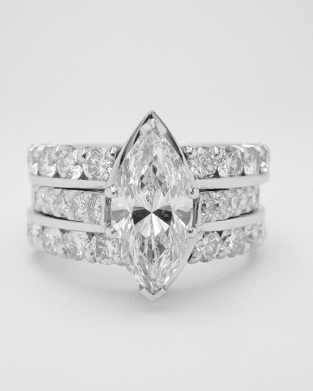 A pair of twin platinum part channel set diamond wedding rings shaped to fit with a single stone straight marquise shaped diamond engagement ring.