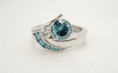 Ocean Blue diamond set platinum wedding ring shaped to fit around a blue & white diamond 2 stone wishbone cross-over platinum engagement ring.