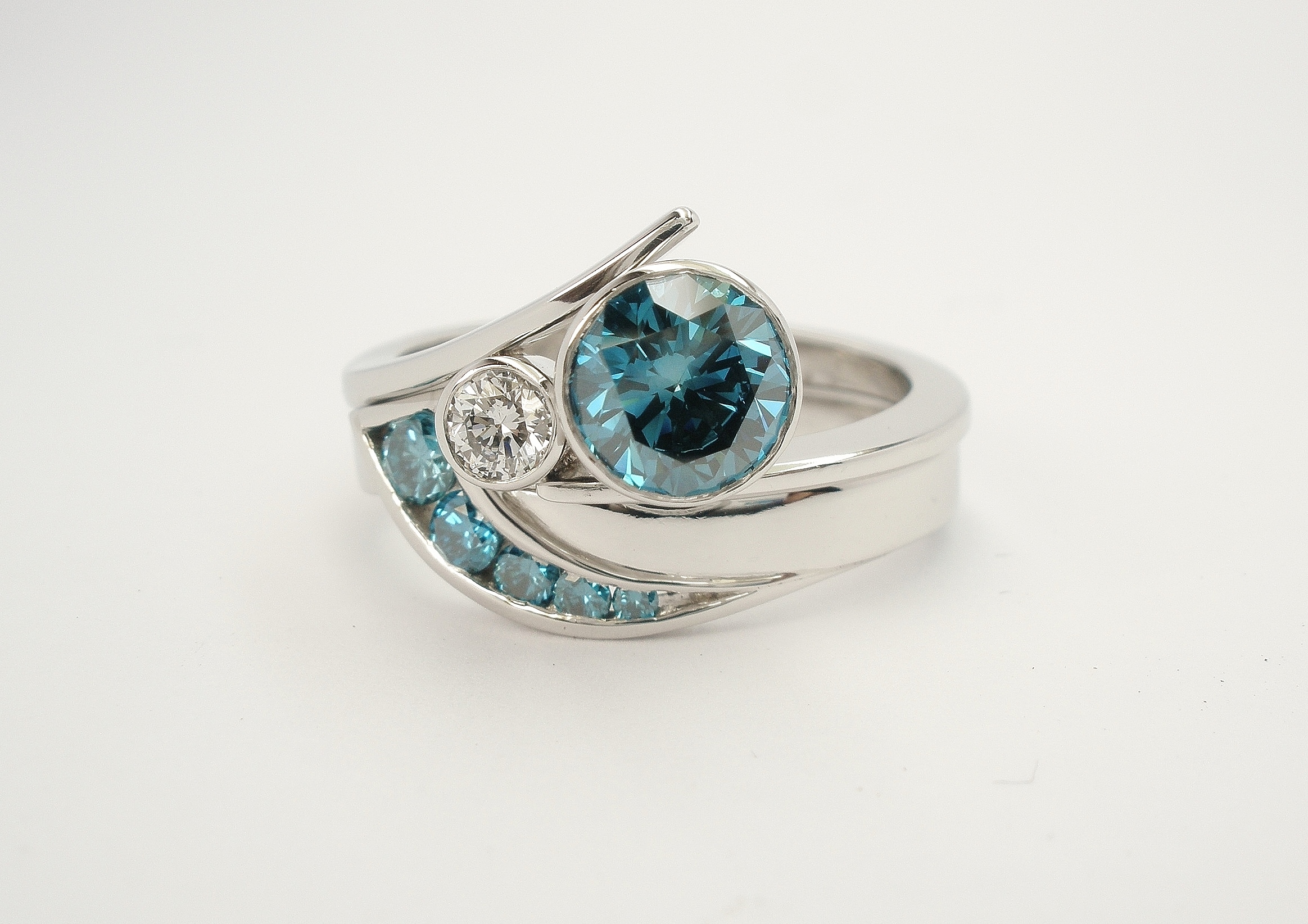 Ocean Blue diamond set platinum wedding ring shaped to fit around a blue & white diamond 2 stone wishbone cross-over platinum engagement ring.
