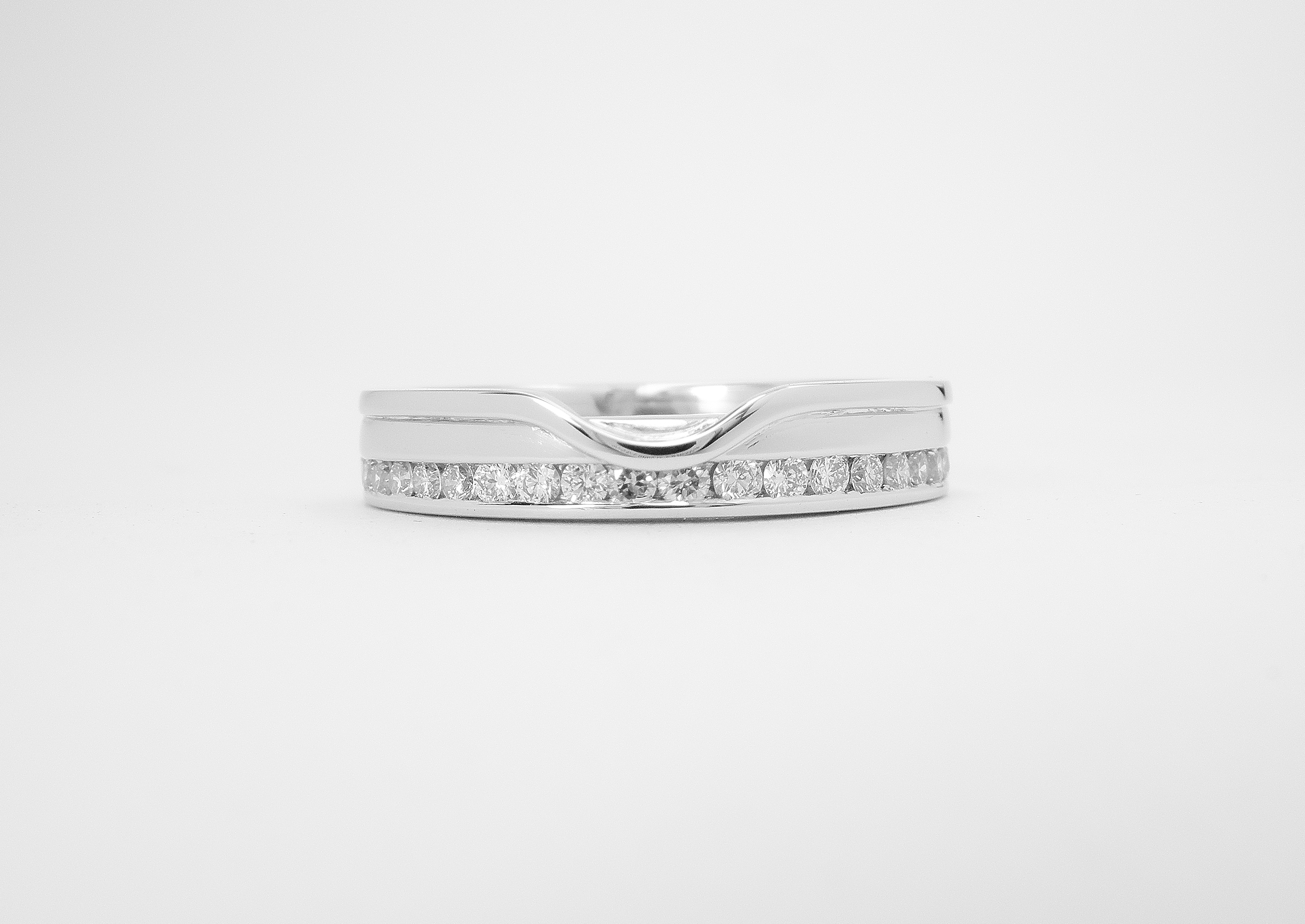18ct. white gold 'Off-set' diamond wedding ring shaped to fit with a single stone straight diamond engagement ring.