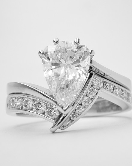 Platinum zig-zag wedding ring shaped to fit a pear shaped cross-over engagement ring, channel set with brilliant cut diamonds to 45% cover. This would also suite a marquise cross-over.