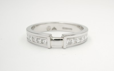 Palladium wedding ring shaped to fit 4 stone princess cut cluster engagement ring, & channel set with princess cut diamonds on either side of raised wires shaped to let in cluster.