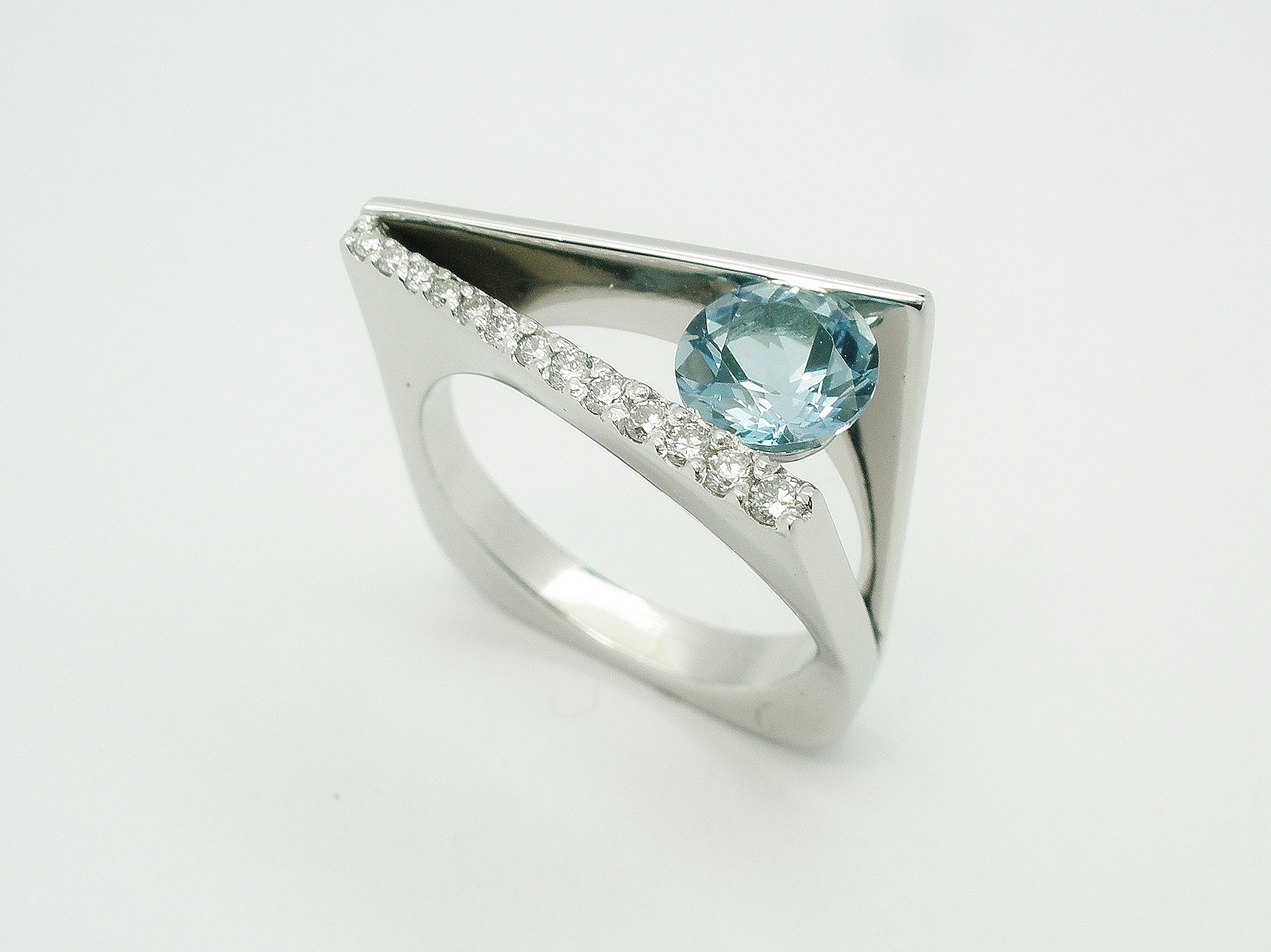 Round aquamarine & diamond 'Wedge' shaped, plateau, square sectioned ring mounted in palladium.