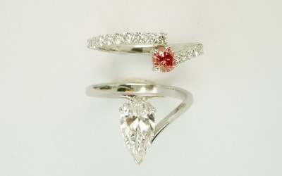 Pink round brilliant cut diamond & white diamond wire set platinum wedding ring shaped to interlock with a single diamond pear wishbone cross-over engagement ring.