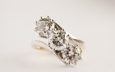 3 stone round brilliant cut diamond, straight cross-over style, right hand ring, mounted in 18ct. yellow gold and platinum.