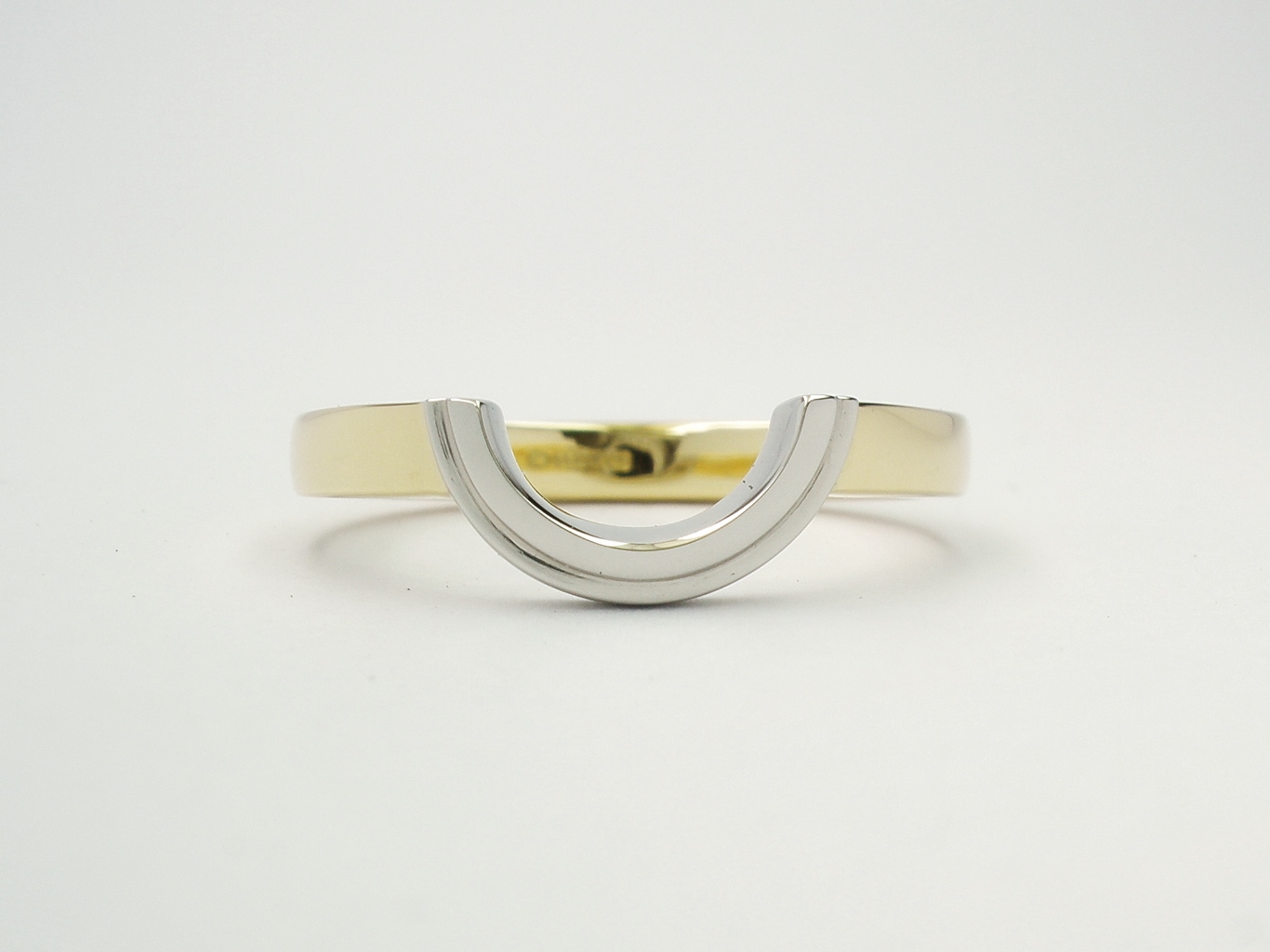 'Arc' shaped wedding ring created in 18ct. yellow gold and platinum to fit around a round diamond cluster engagement ring.
