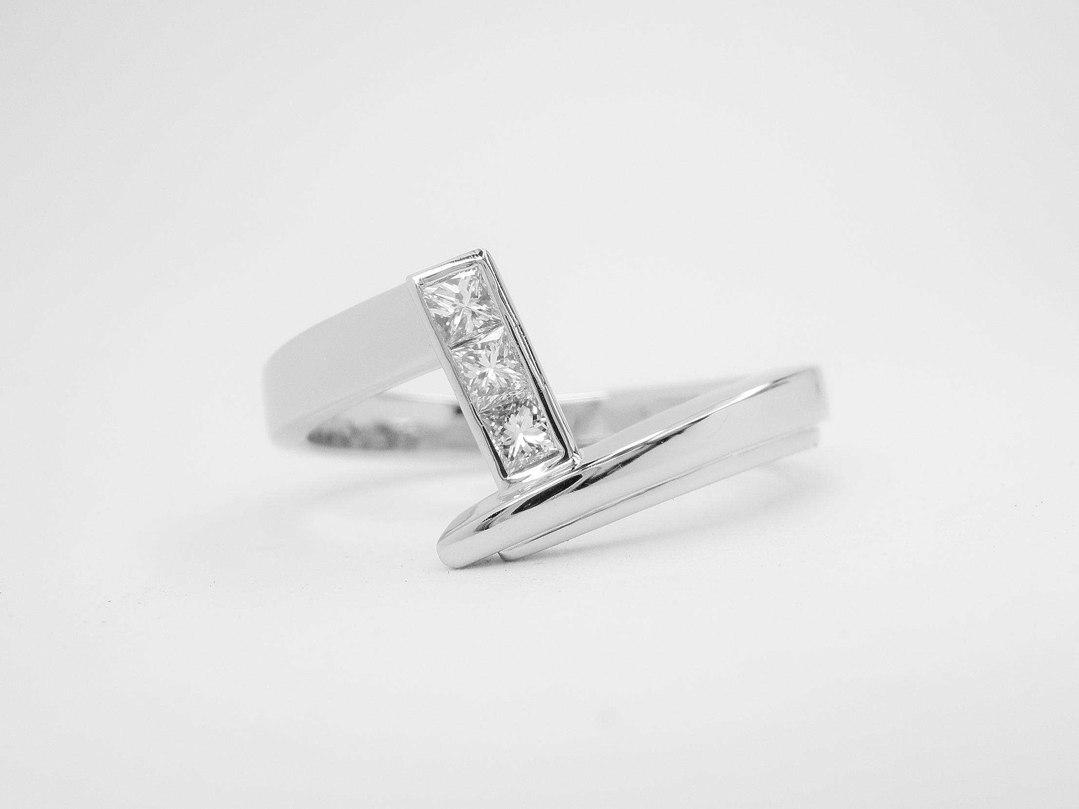 Zig-zag' platinum wedding ring shaped to fit a princess cut diamond cross-over engagement ring set with 3 princess cut diamonds.
