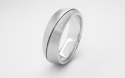 Palladium flat 'V' sectioned gents wedding ring with darkened orbital line cut, polished finish one side & rough texture on other.