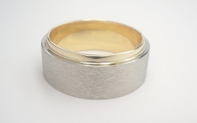 9ct. yellow gold gents wedding ring with a brushed finish palladium ring overlaid across 80% of the 9ct. yellow gold ring.