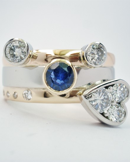 The clients brief was to include the 2 wedding rings, all the diamonds and the large sapphire and she wanted a heart shape somewhere on the ring.