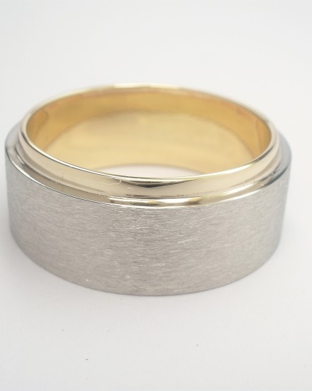 The gentleman had his fatherâ€™s 9ct. yellow gold wedding ring which he wished incorporated into his wedding ring although he wanted his ring to be predominantly white metal. Although the fatherâ€™s ring was very wide it suited the clients finger allowing Alan to size to fit then overlay a palladium band to 75% of the width allowing the 9ct. yellow gold inner ring to show.