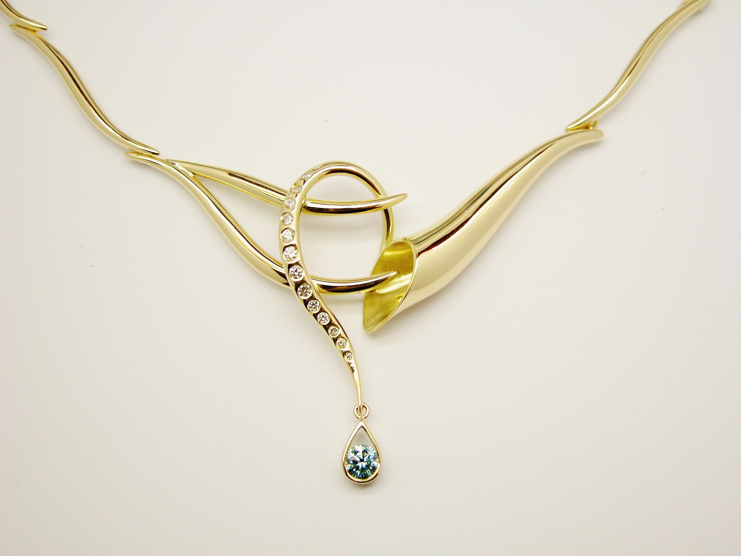 Hand crafted 18ct. yellow gold horn & loop shaped centre panel necklace flush set with round white diamonds and 1 sky blue round diamond & individually made links.