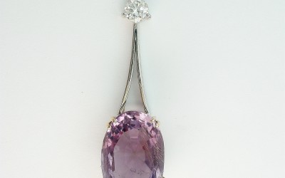 Oval amethyst and round brilliant cut diamond wishbone split wire pendulum style pendant.
