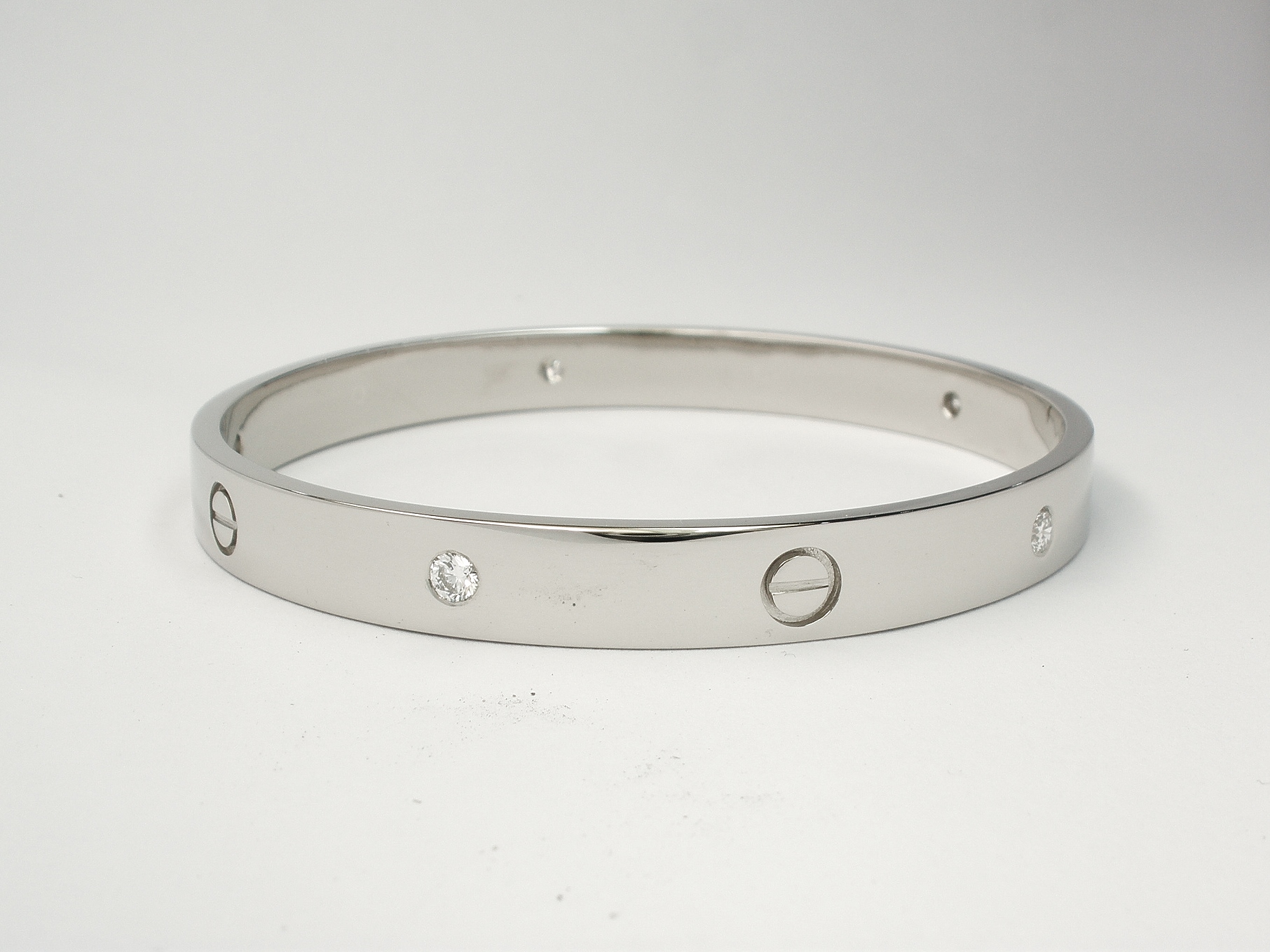 Palladium heavy sectioned bangle flush set with round brilliant cut diamonds and recessed screw heads.
