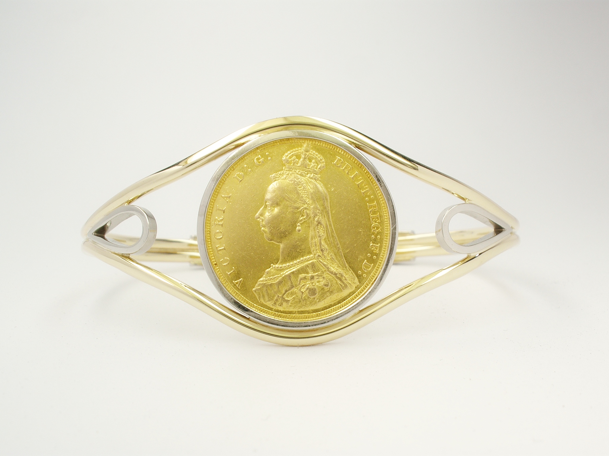 9ct. yellow gold and palladium torque bangle mounted with a single gold full sovereign coin.