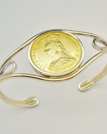 9ct. yellow gold and palladium torque bangle mounted with a single gold full sovereign coin.