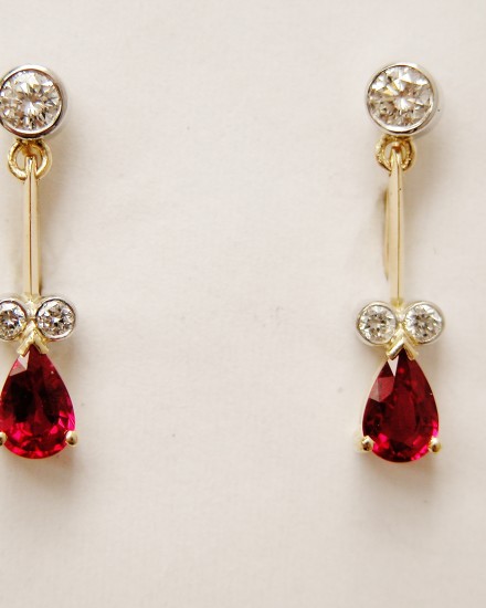 Pear shaped ruby and diamond 18ct. yellow gold pendulum style earrings.