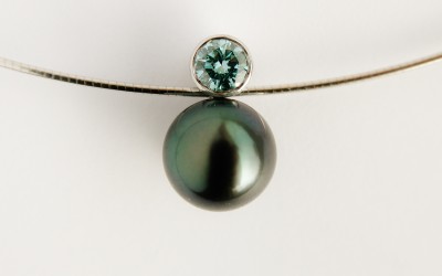 Black Tahitian pearl & ocean blue diamond pendant mounted in 18ct. white gold.