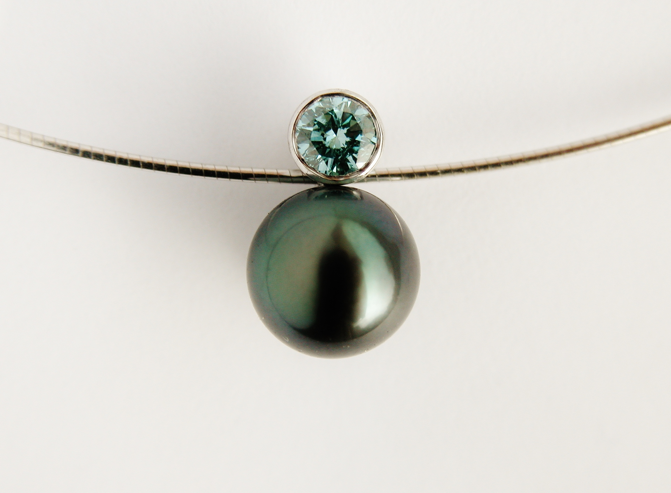 Black Tahitian pearl & ocean blue diamond pendant mounted in 18ct. white gold.