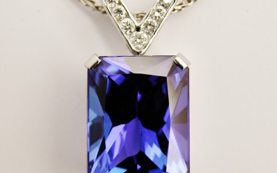 Emerald cut tanzanite pendant set in platinum with a diamond set 'V' shaped platinum shackle.