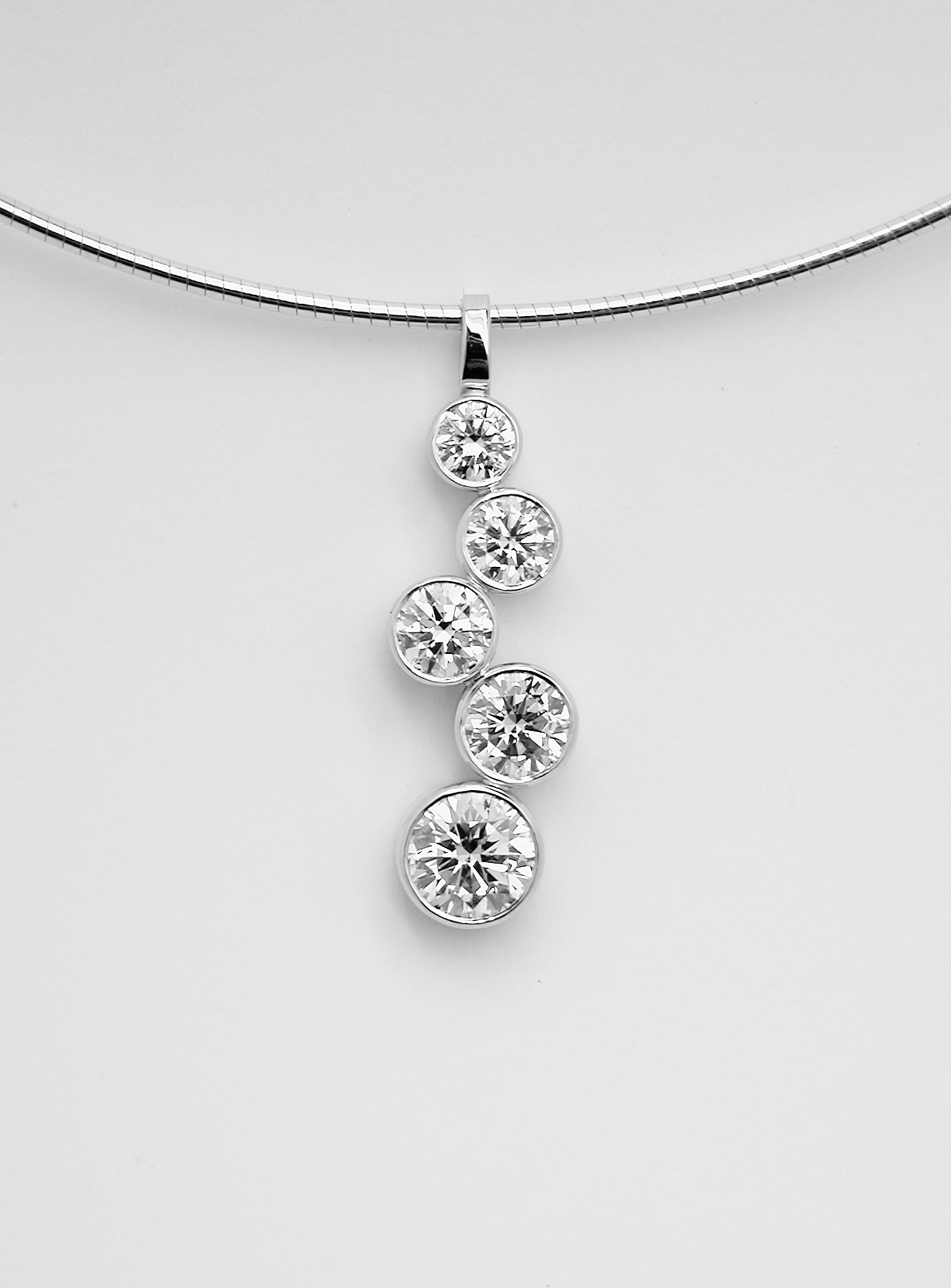 5 stone rub-over set round brilliant cut diamond 'tumble' pendant.