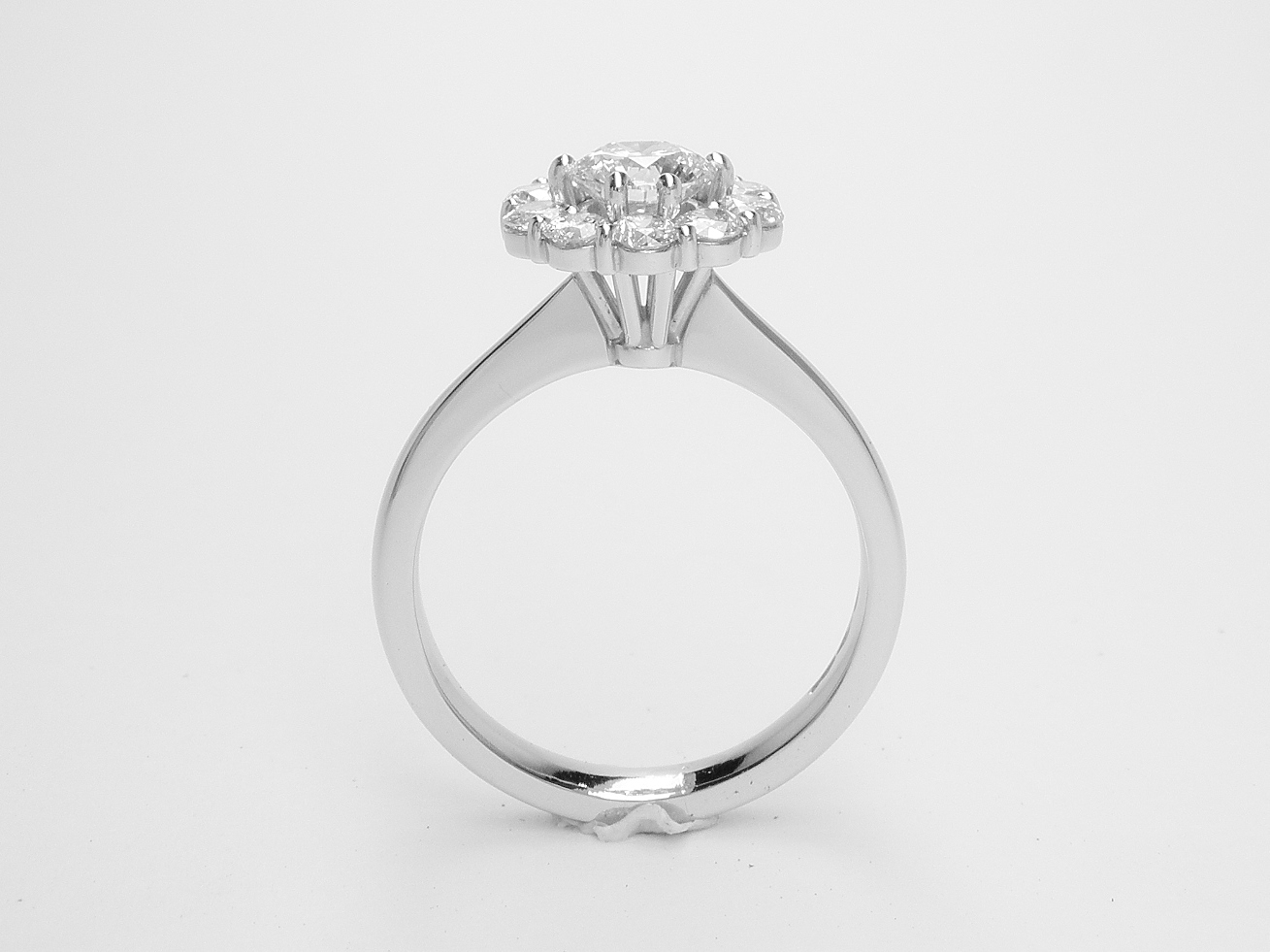A halo cluster ring comprising 11 round modern brilliant cut diamonds set in platinum. 0.50ct. 'E' colour centre diamond.