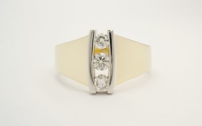 3 stone round brilliant cut diamond vertically channel set 18ct. yellow gold and platinum ring.
