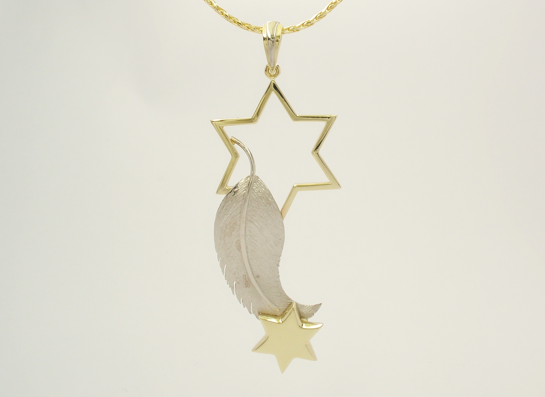 18ct. yellow gold and palladium feather and star pendant.