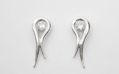 Palladium tapered loop earrings with a single round brilliant cut diamond set in loop.