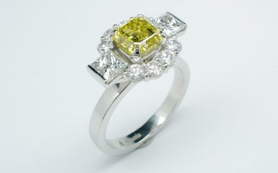 Canary yellow Asscher cut diamond (1.20cts.), white princess cut and round brilliant cut diamond 'Halo' cluster ring mounted in platinum.
