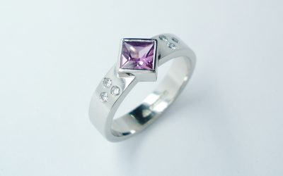 Square princess cut rub-over set purple sapphire and flush set diamond ring mounted in palladium.