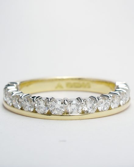 Round brilliant cut diamond eternity ring part channel set to 55% cover, mounted in 18ct. yellow gold and platinum