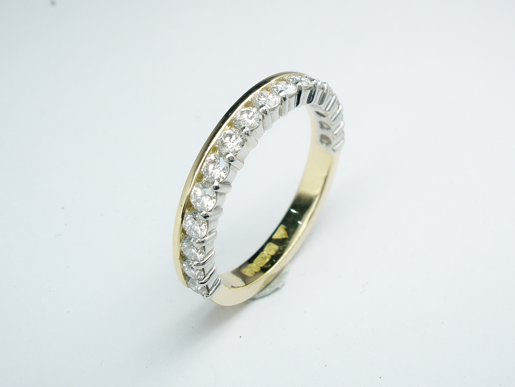 Round brilliant cut diamond eternity ring part channel set to 55% cover, mounted in 18ct. yellow gold and platinum